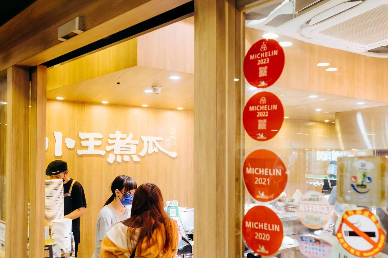 台北華西街一家連續多年榮獲米其林推薦的知名小吃店「小王煮瓜」外觀，強調龍山寺美食之旅中探訪星級美味的體驗。