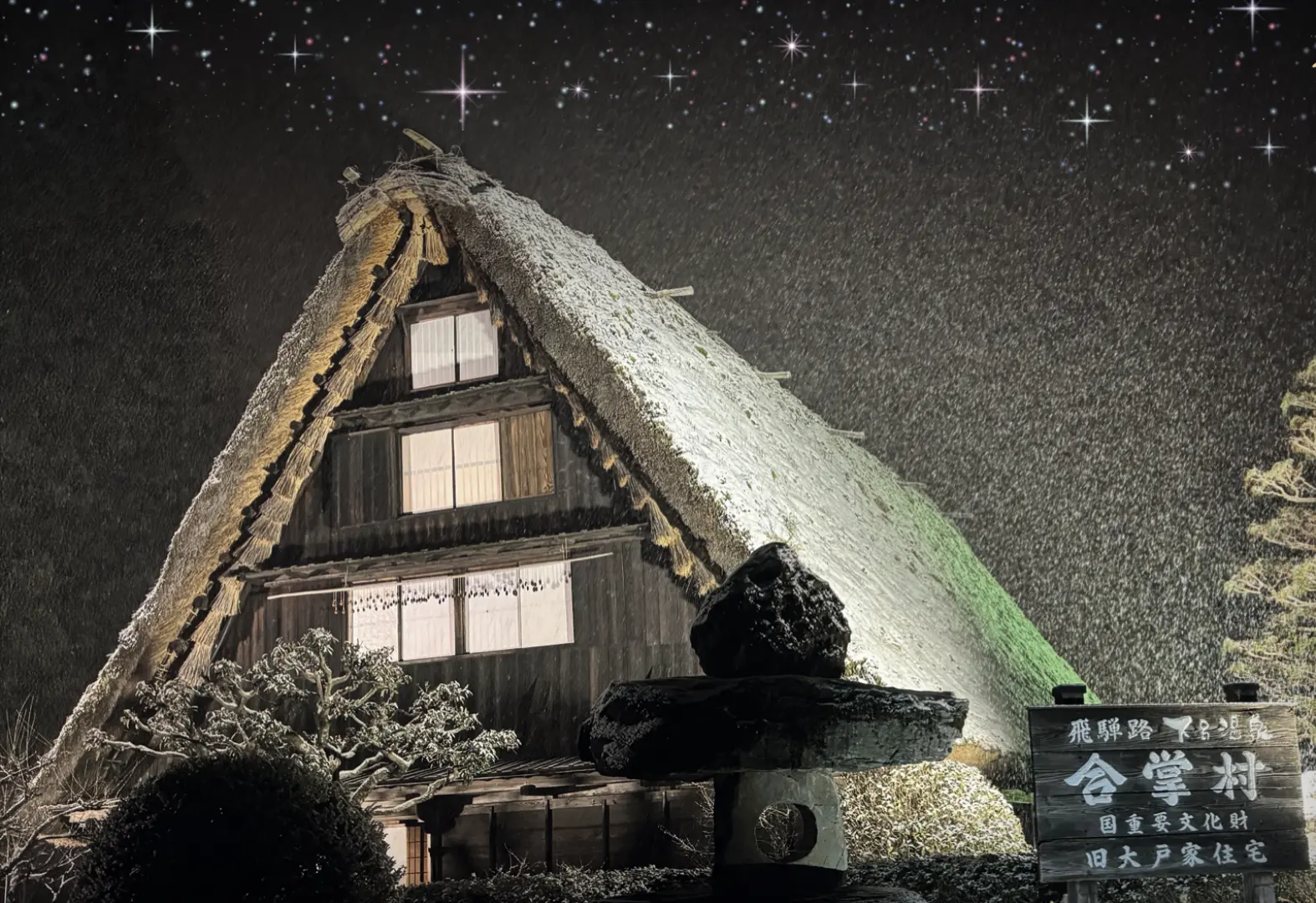 The enchanting Gero Onsen Gassho Village illuminated at night during winter, with traditional thatched-roof houses glowing under a starry sky, offering a magical Chinese New Year spectacle.