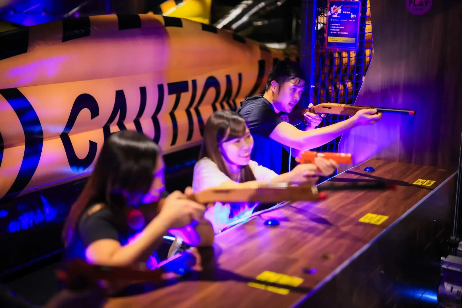 荔枝角PowerPlay Arena競技遊戲區Zone B，三位朋友正投入於射擊遊戲中，目標明確，考驗精準度。