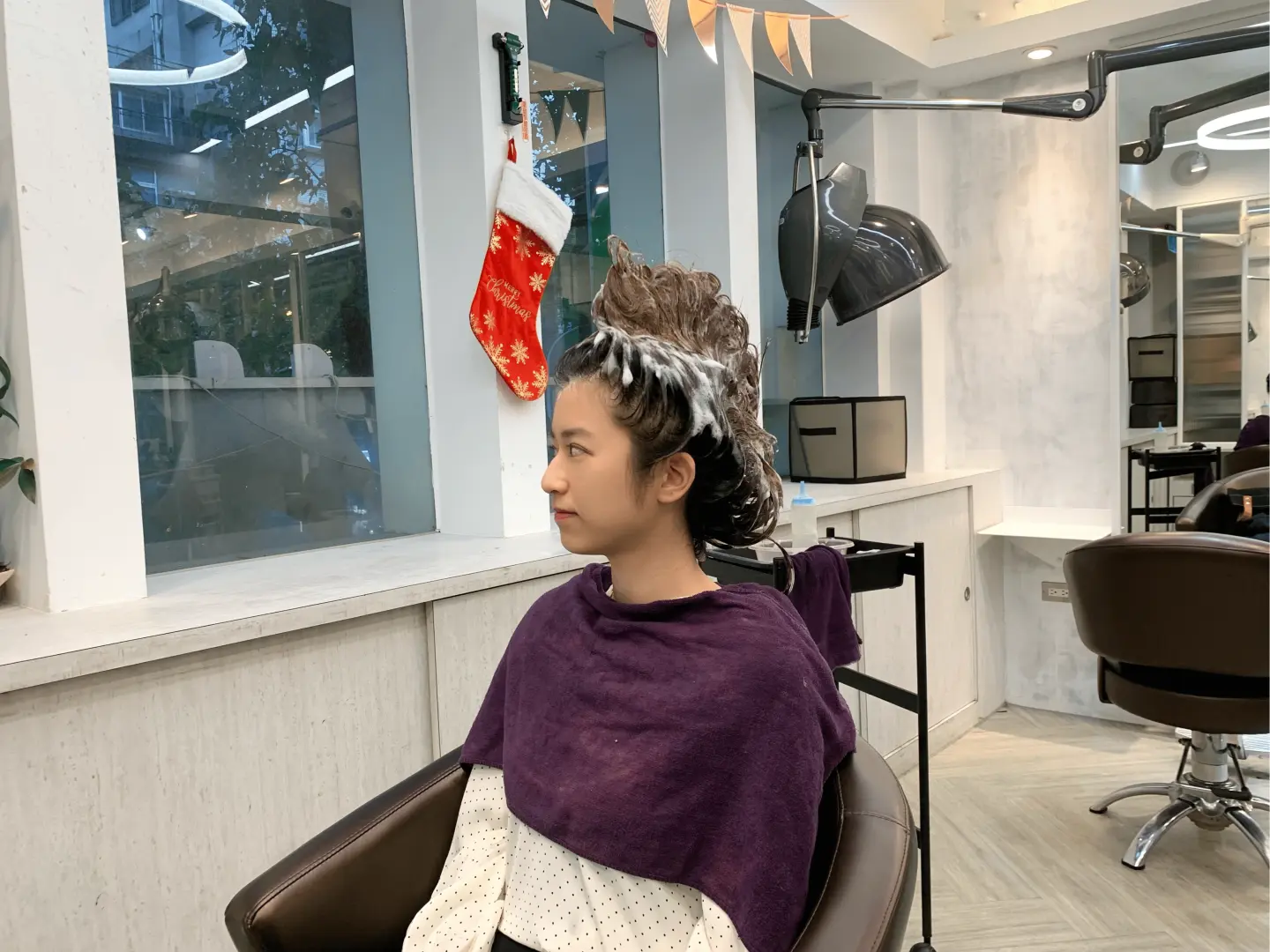 台北の小林ヘアサロンで台湾式座りシャンプーのユニークな体験を楽しむお客様。ふわふわの泡のスタイリングは遊び心があり、SNS映えにも最適です。