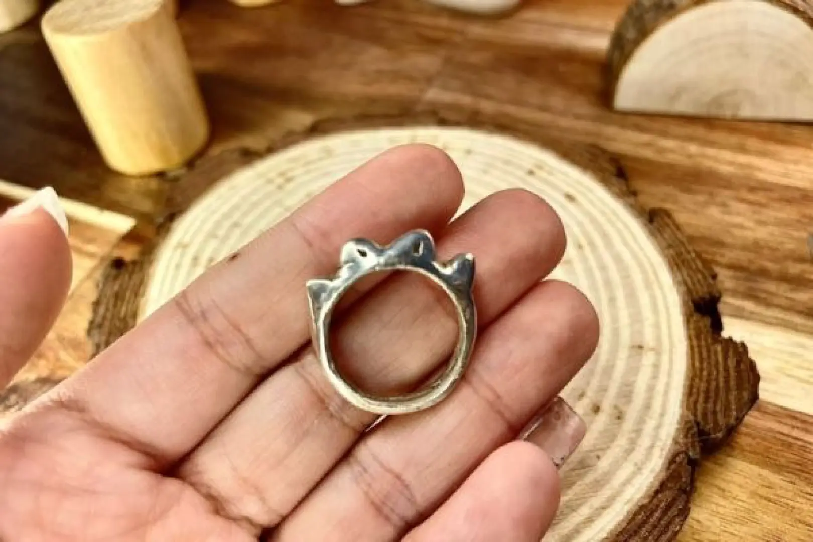 一位學員手持在馬六甲DIY銀飾工作坊中製作的獨特純銀戒指，展示其作為紀念品的精緻細節與錘打工藝。