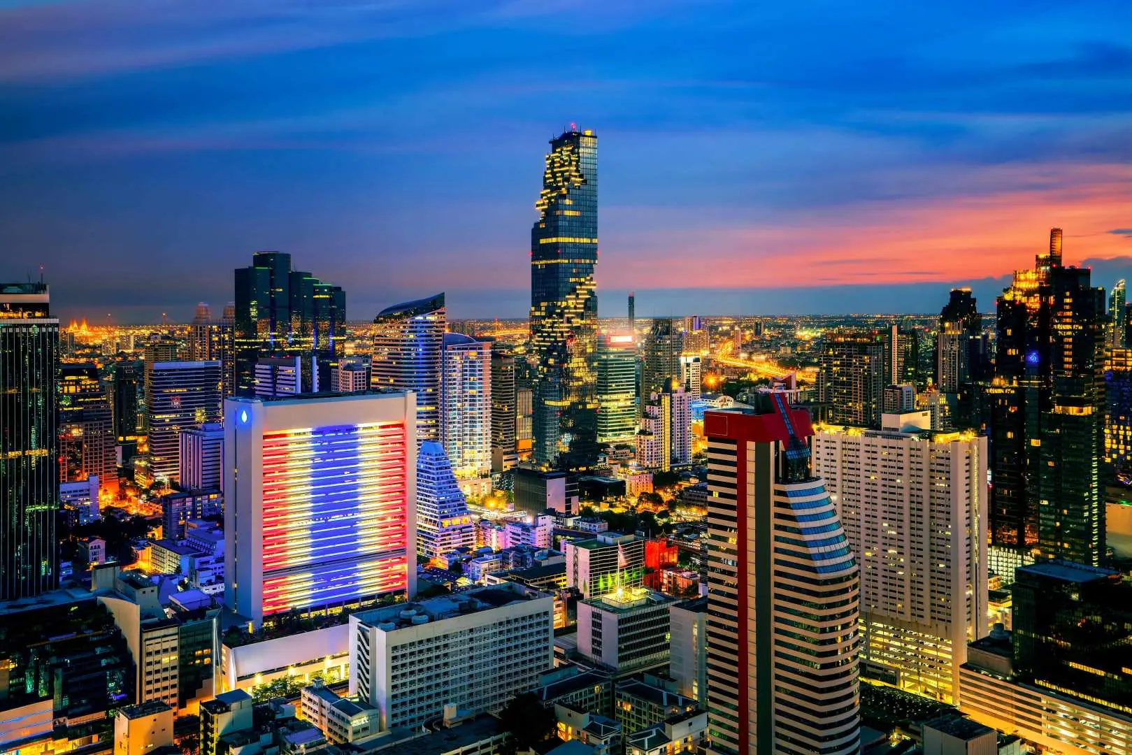 Bangkok's dazzling city night view, with brightly lit skyscrapers outlining the skyline, including the iconic Mahanakhon Skywalk, offering stunning panoramic vistas.