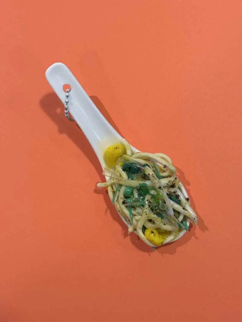 京都食品樣品體驗的另一款作品，白色湯匙內有綠色麵條與黃色配料的仿真食物模型，可當作鑰匙圈或擺飾。