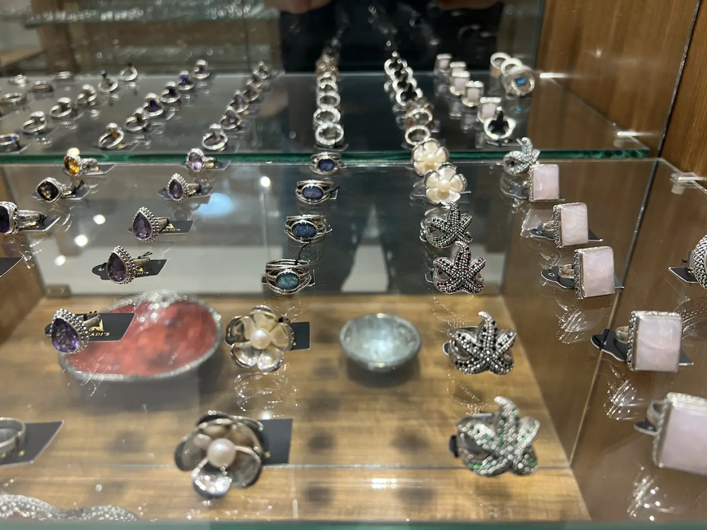 峇裡島Arnadi工作坊藝廊中，玻璃櫃展示著精緻手工銀戒指，設計有花朵和葉子等細膩形狀。