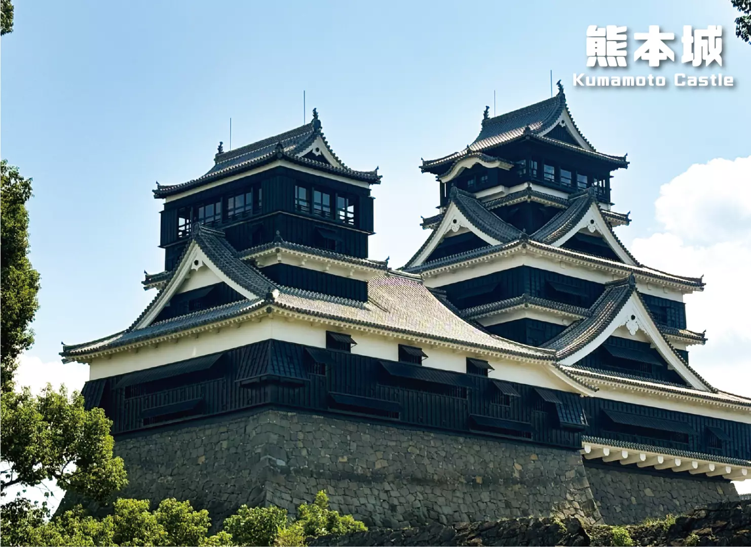 熊本城雄伟壮丽的天守阁外观，深色屋顶与白色墙面错落有致，展现日本三大名城的独特建筑美学。