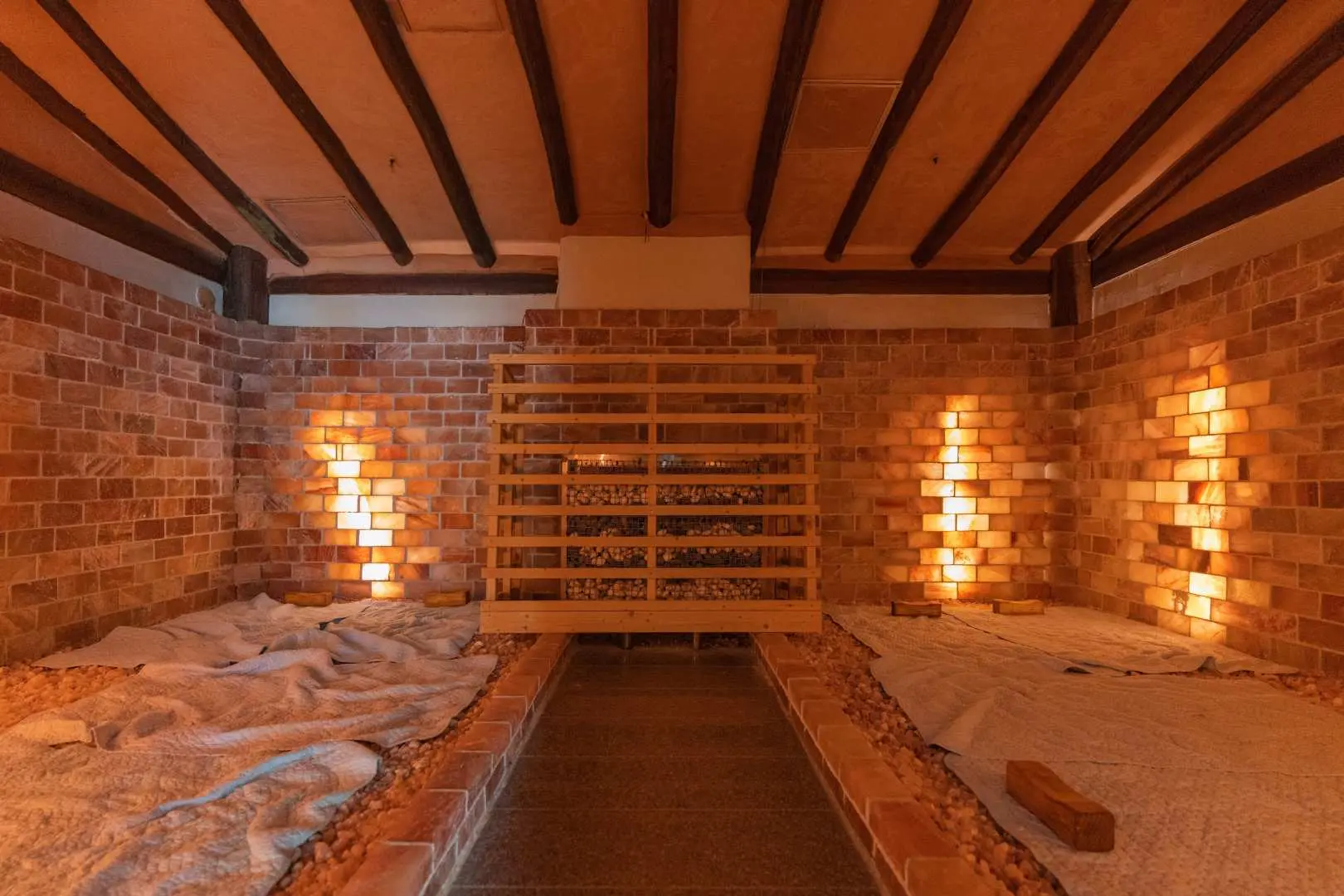 Interior of Busan Haeundae HILL SPA's warm and comfortable Korean jjimjilbang, with brick walls and wooden ceiling creating a traditional ambiance, offering an excellent relaxing experience with soft lighting.