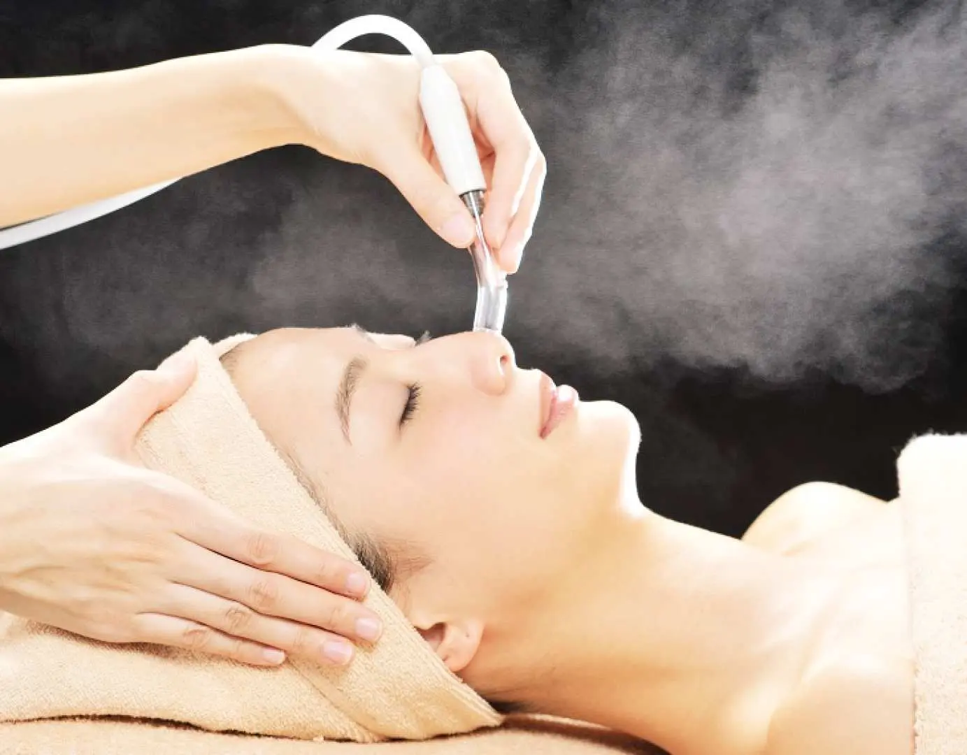 A woman receiving a deep pore cleansing facial with steam application at a popular Ginza, Tokyo beauty salon, effectively removing blackheads and keratin plugs for clearer skin.
