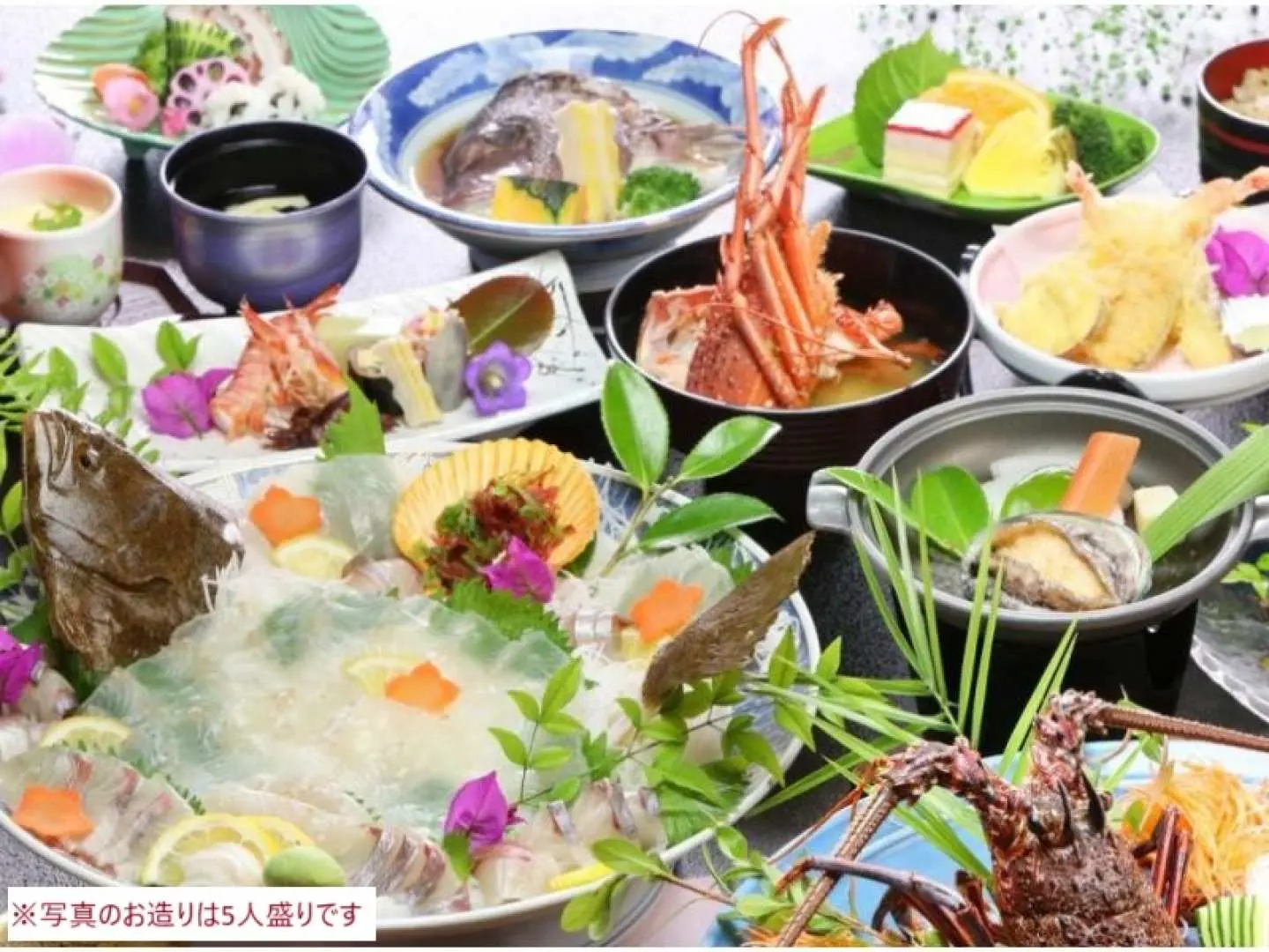 豪華な天草の旬の海鮮ランチ。新鮮な刺身、ロブスターのグリル、天ぷらなど、天草ならではの豊かな味覚を堪能できる料理が並びます。