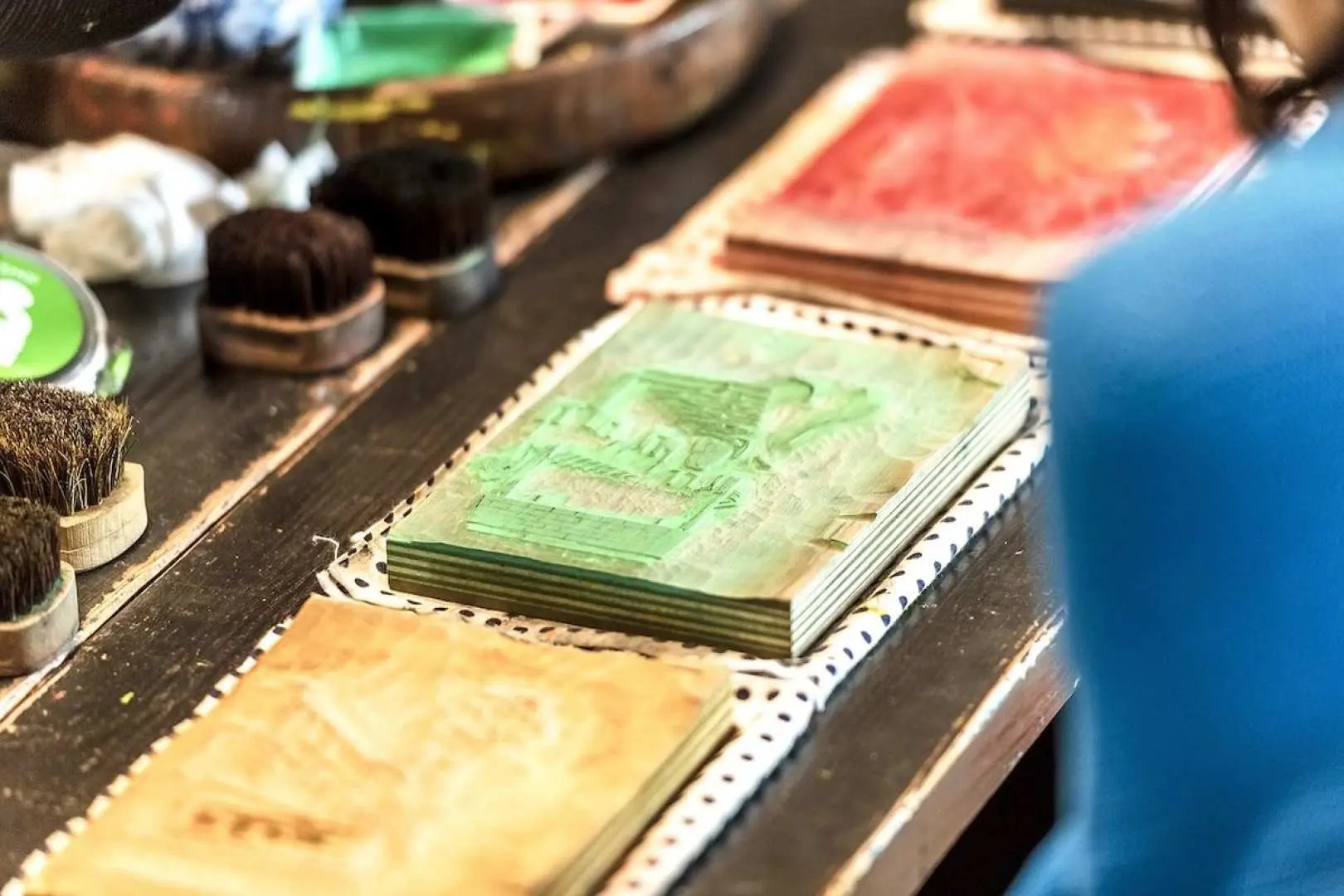 浮世繪版畫製作體驗的工具近景，多個塗有不同顏色的獨家版木與專業刷具，準備進行多色印刷步驟。