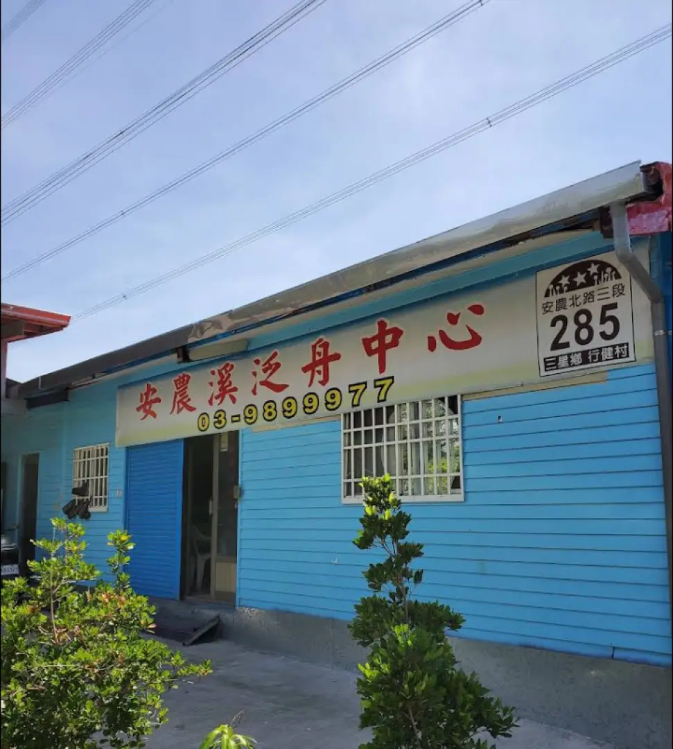 宜蘭安農溪激流泛舟中心外觀，藍色建築物上清晰標示著中心名稱與地址，是參加安農溪泛舟活動的集合報到地點。