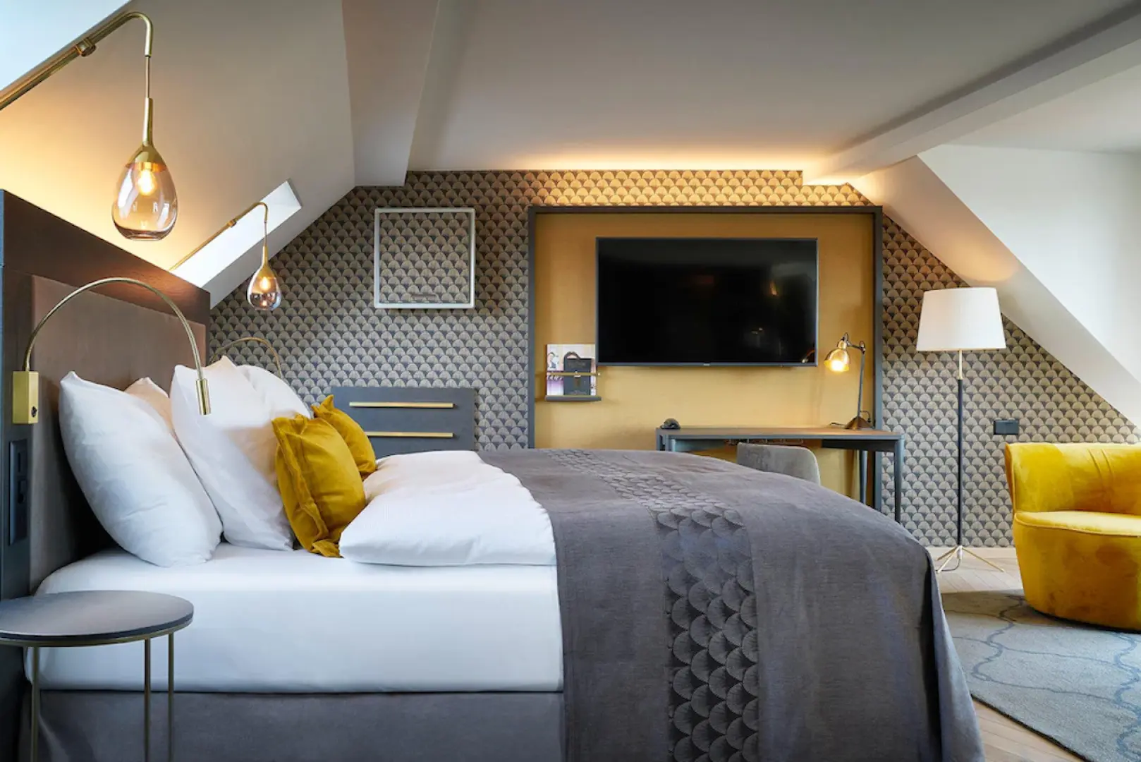 Comfortable and modern Swiss hotel room interior, featuring a spacious double bed, stylish yellow armchair, and TV, offering a cozy and excellent accommodation experience.