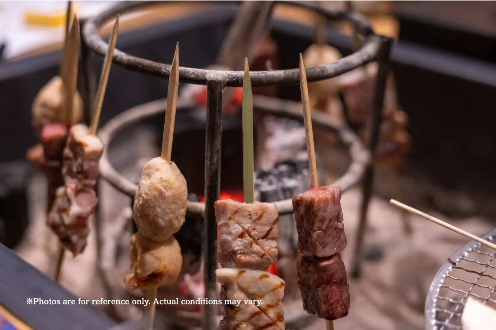 多种高级肉串在传统围炉里炭火上滋滋作响，呈现东京神乐坂百年料亭“围炉里烤肉 祇园”经典的日式烧烤美味。