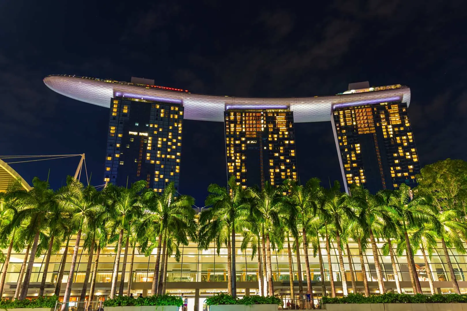 夜のシンガポール、マリーナベイ・サンズ・ホテル。壮大な建築物がライトアップされ、威厳に満ちた姿を見せています。シンガポール夜間遊覧船の象徴的なランドマークです。