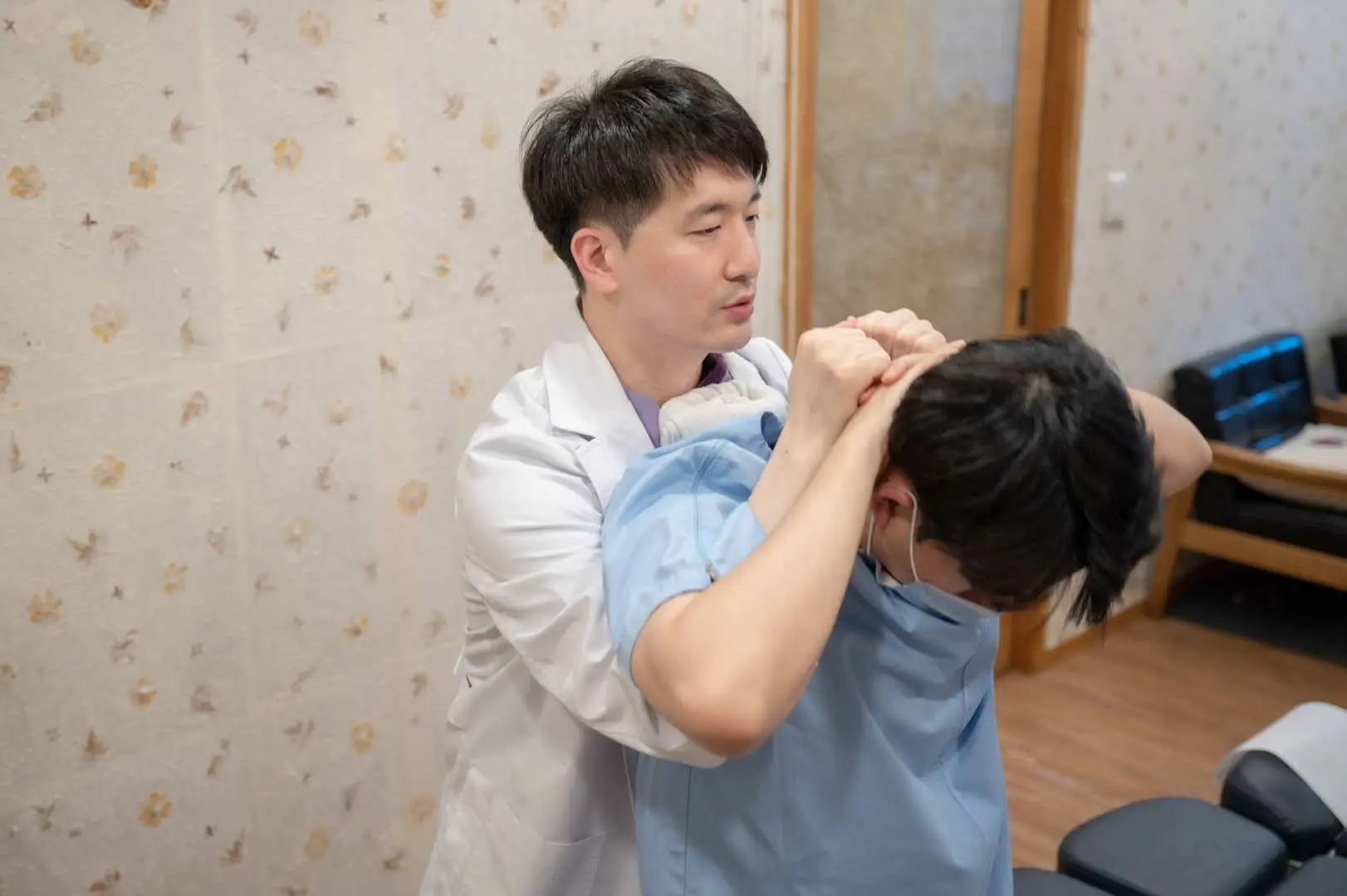 首爾通仁韓醫院的專業醫生正在進行推拿療法，這是一種韓國傳統徒手調整技術，用於脊椎對齊和緩解疼痛。