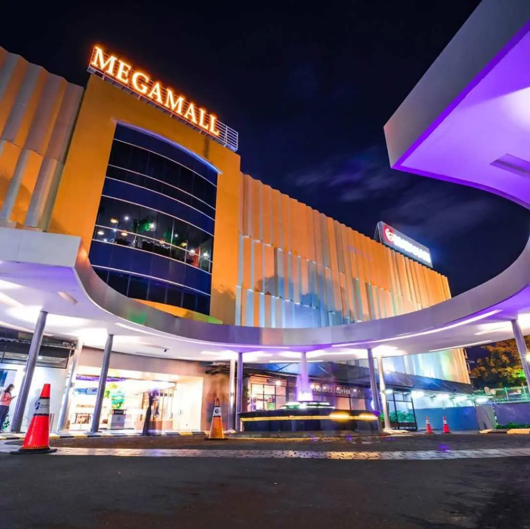 巴淡島Megamall購物中心在夜間燈火通明，現代化建築為紅樹林之旅旅客提供高檔購物與休閒娛樂體驗。