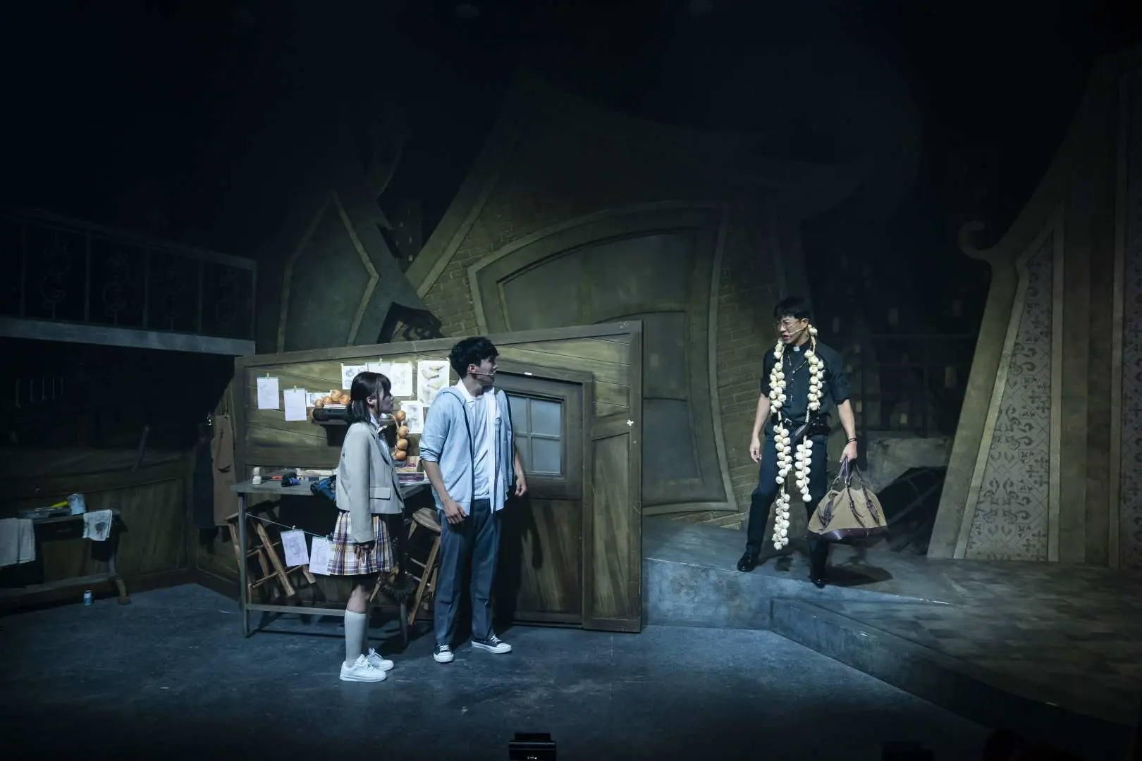 音樂劇《VAMP X HUNTER》舞台場景，三位演員在昏暗燈光下對話，展現角色間的細膩情感交流與劇情發展，舞台佈景簡潔而富有故事感。