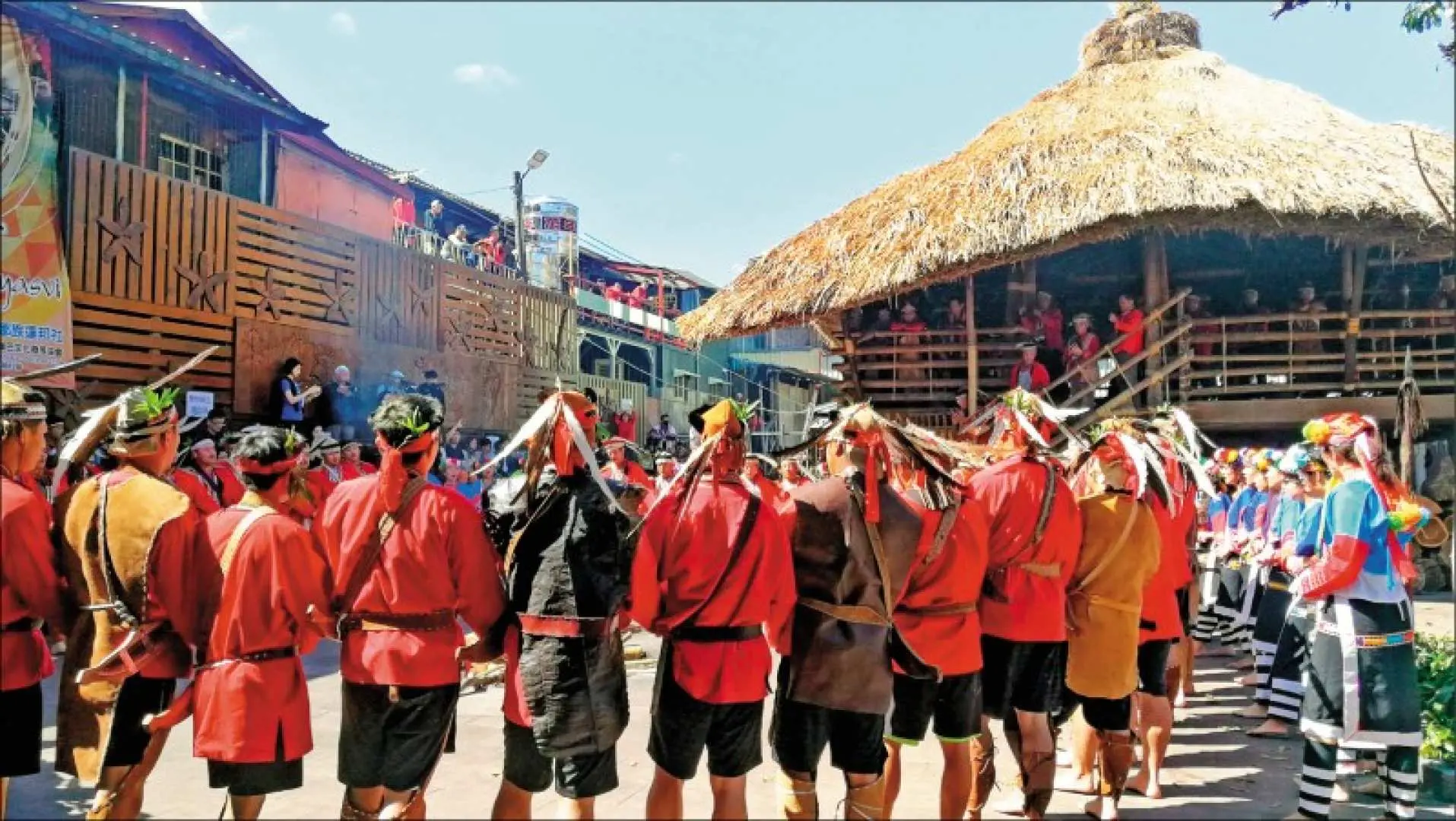 优游吧斯部落的男性居民身着传统服饰，在阳光下的文化园区进行集会，展现嘉义包车一日游丰富的原民风情。