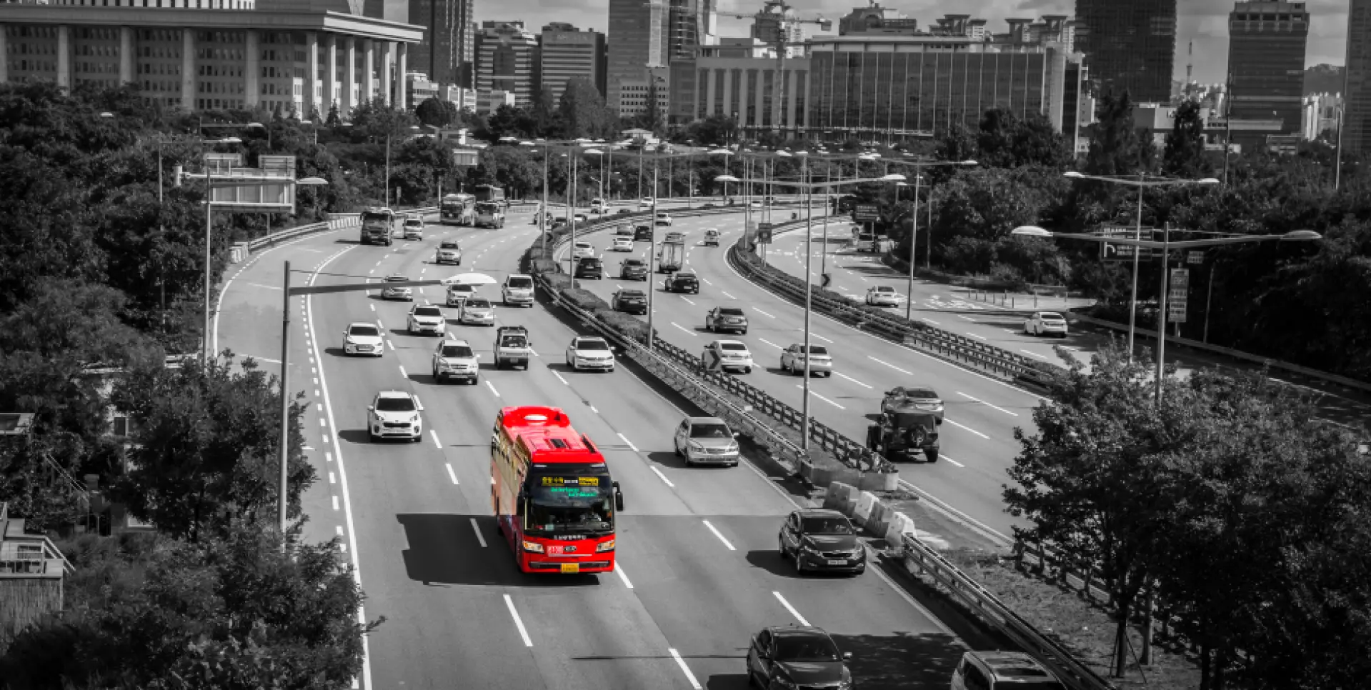 A red 6100 Incheon Airport luxury bus traveling on a Seoul city highway, symbolizing convenient transportation to the downtown Nowon-gu and Jungnang-gu districts.