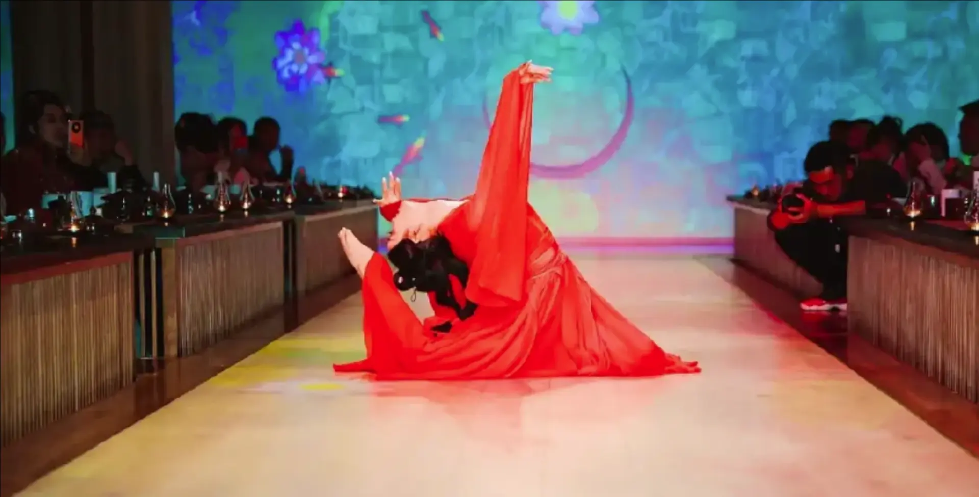 A dancer in a vibrant red Hanfu performs classical dance on an immersive digital light and shadow stage at the Beijing Palace Banquet, offering an imperial audio-visual feast.