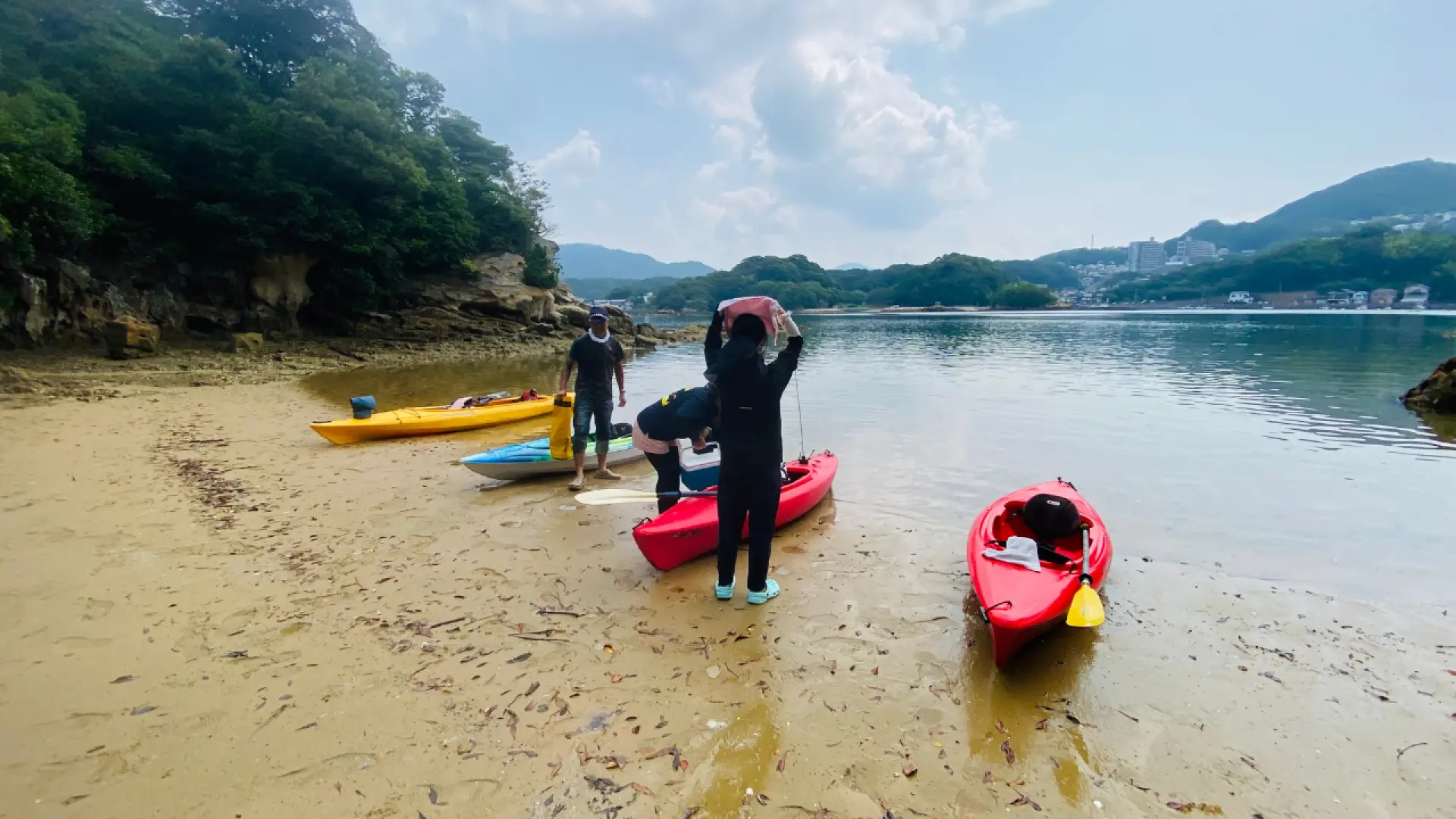 獨木舟登陸無人島，遊客在沙灘上協助準備皮划艇，準備享受島嶼的悠閒時光。