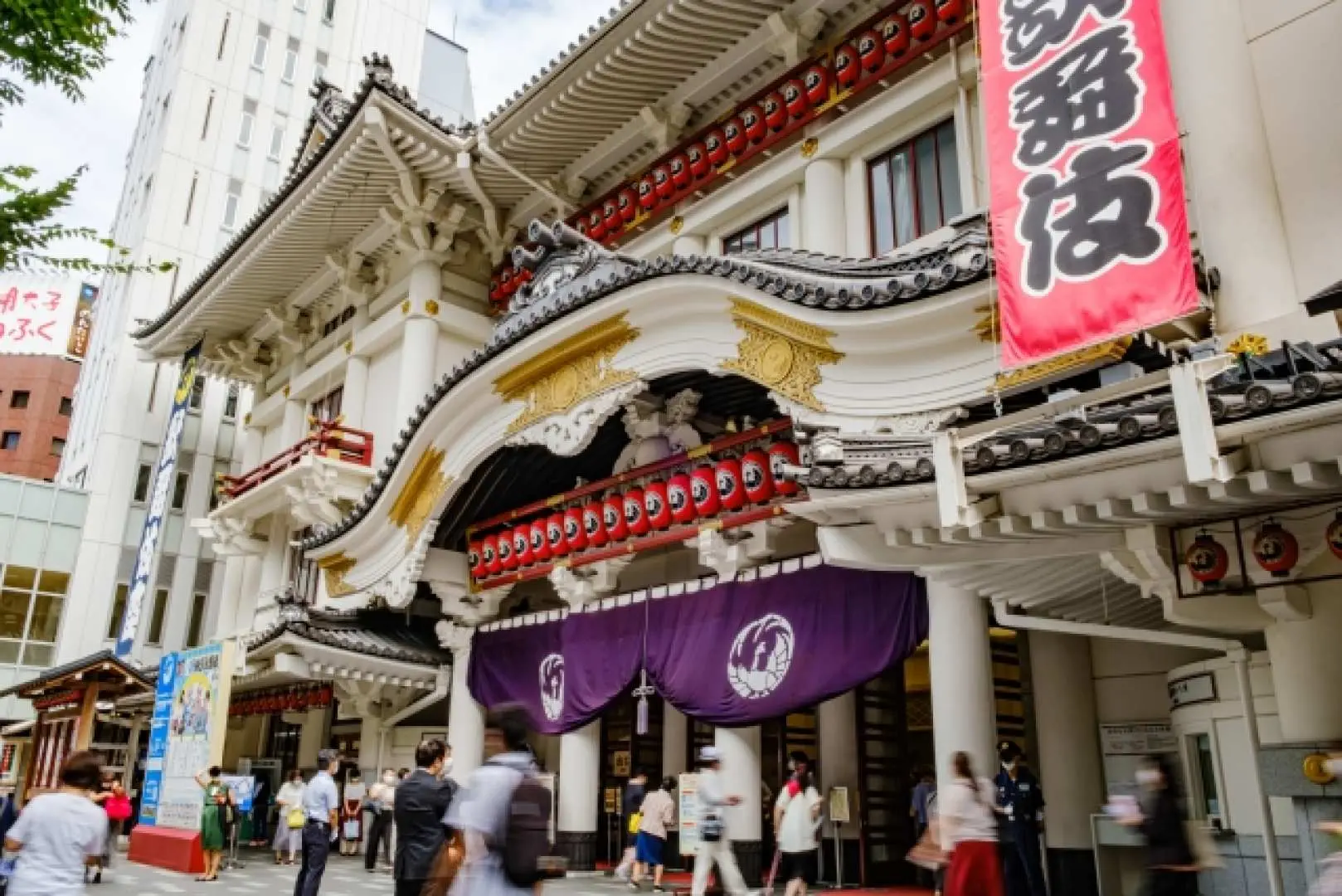 東京銀座の歌舞伎座劇場外観。壮麗な伝統的な日本建築で、赤い提灯と紫の幕が飾られ、文化探訪のランドマークです。
