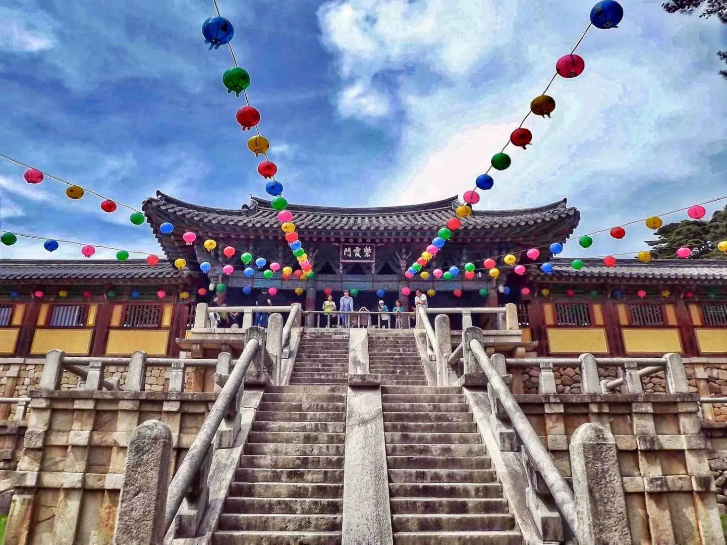 Majestic entrance of Bulguksa Temple in Gyeongju, with intricate stone staircases and traditional architecture adorned with colorful lanterns, welcoming visitors to this ancient Silla site.