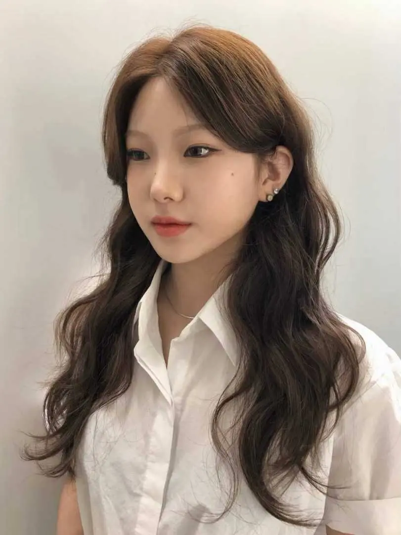 JUNO HAIR客制化发型设计，女性顾客的长卷发呈现蓬松自然弧度，搭配恰到好处的层次，打造完美韩系日常造型。