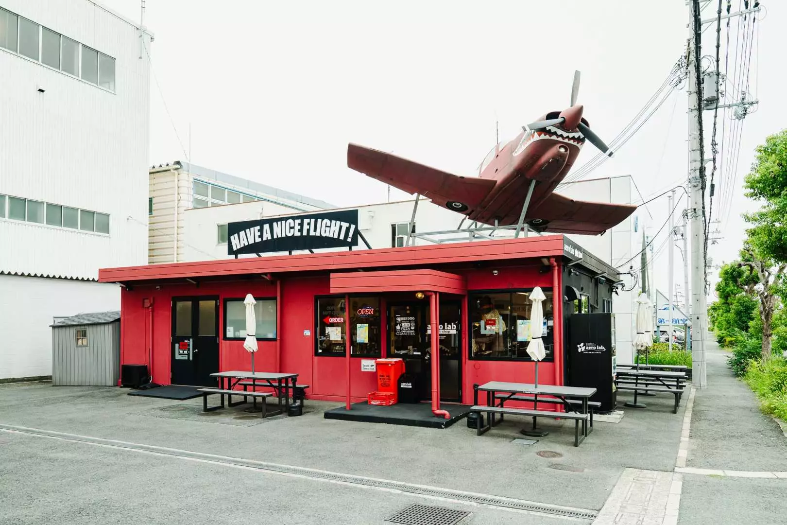 飛機主題專賣店的紅色建築外觀，屋頂上有一架小型飛機模型，歡迎飛行迷前來參觀。