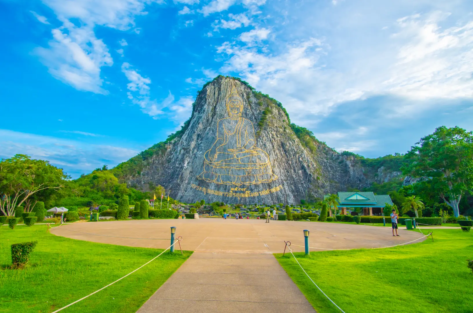 芭堤雅考奇禅寺，壮观的山壁雷射佛像在蓝天下闪耀，周围绿意盎然，是半日私人游的独特景点。