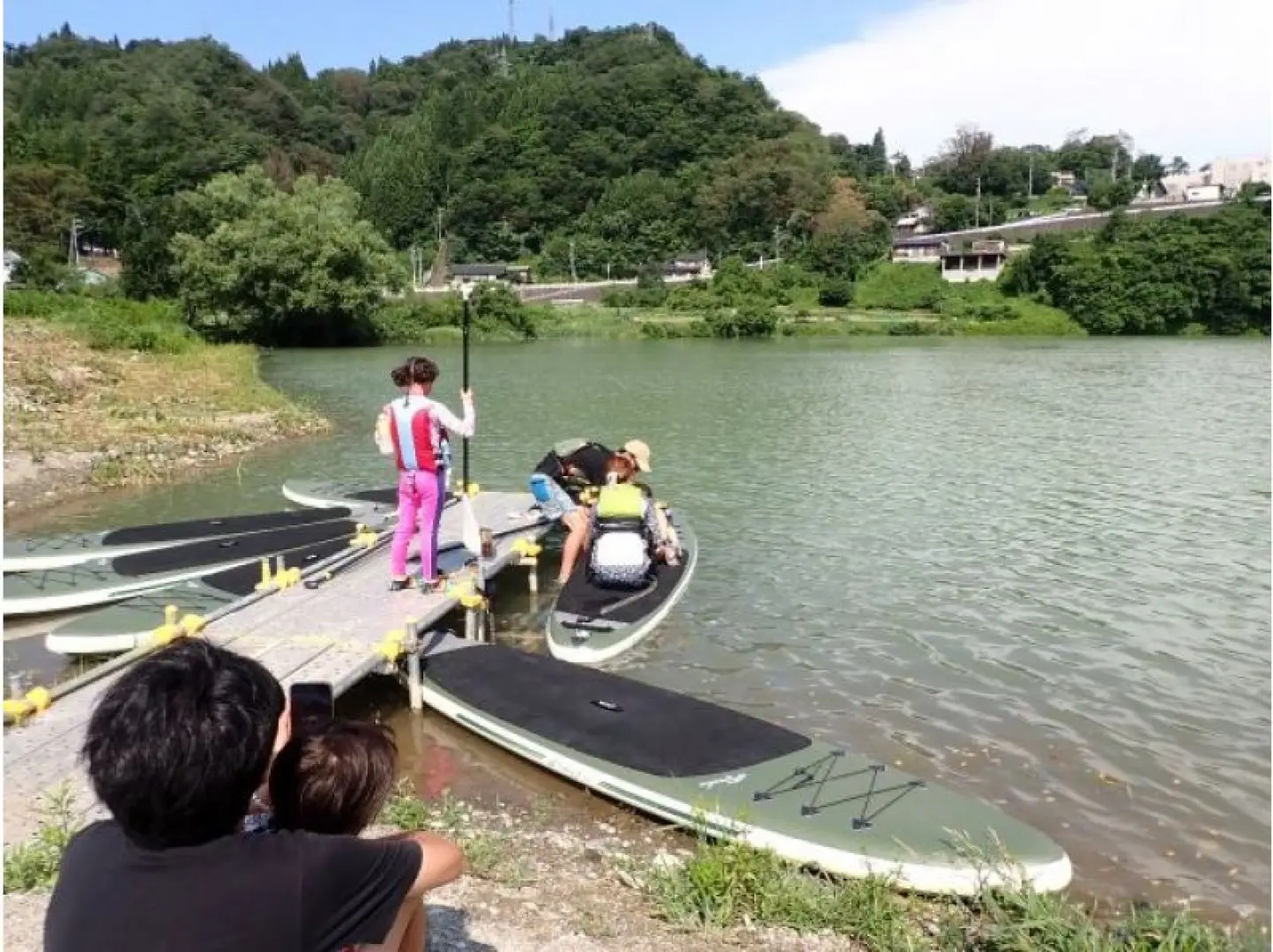 出廷。桟橋から湖に出ます。SUP（Stand Up Paddle Board）とは言っても最初はみんな座ってスタートします。水に浮かぶ感覚とパドルを使ってボードをコントロールする方法を身に付けていきます。座っている状態で水に落ちることはないので安心して練習出来ます。
