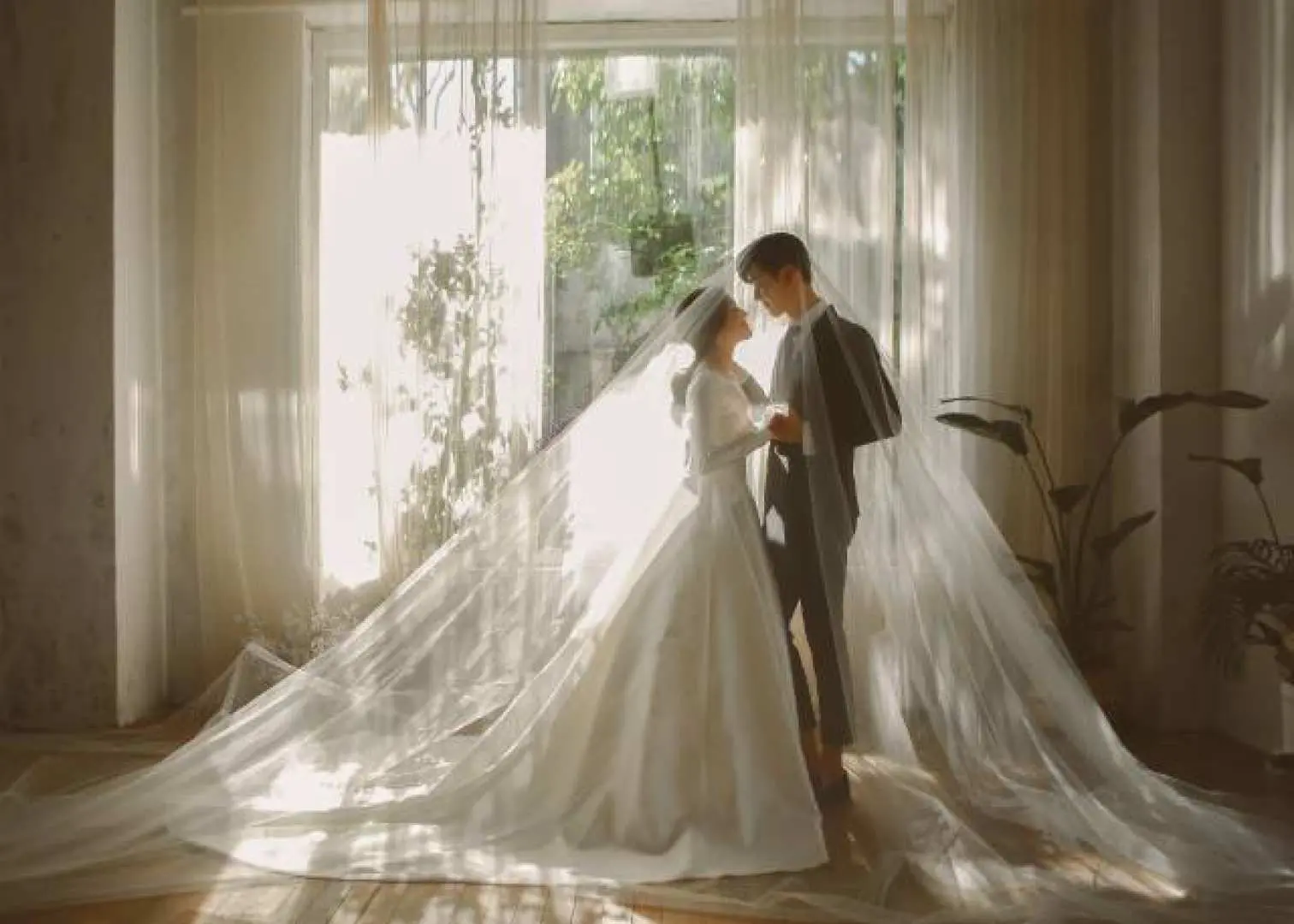 韓國首爾S.A. Wedding輕婚紗，新人在明亮窗邊，長長的拖地頭紗營造出聖潔浪漫氛圍。