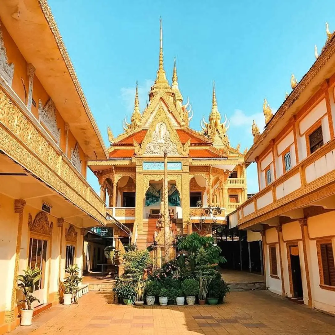 An exquisite golden Buddhist temple with ornate spires and intricate carvings, a cultural stop on the Mekong Delta tour, showcasing Vietnamese traditional architecture.
