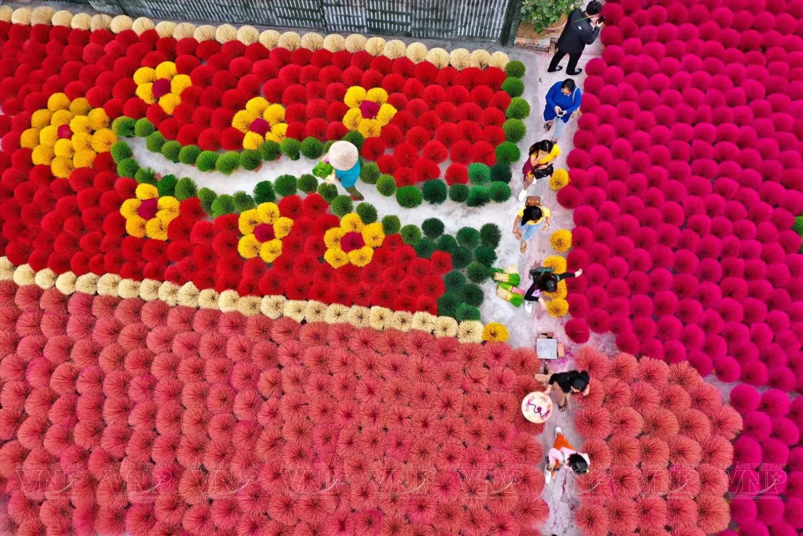 An elevated view of Hanoi's Incense Village, with visitors walking through fields of colorful traditional incense sticks, experiencing the unique charm and culture of Vietnamese handmade incense production.