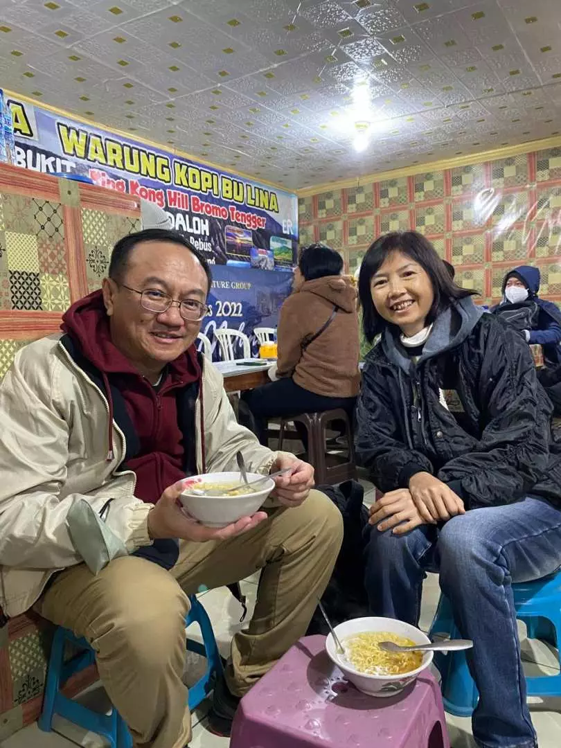 一對笑容滿面的情侶在東爪哇當地餐館享用熱騰騰的餐點，為一天的探險補充能量。