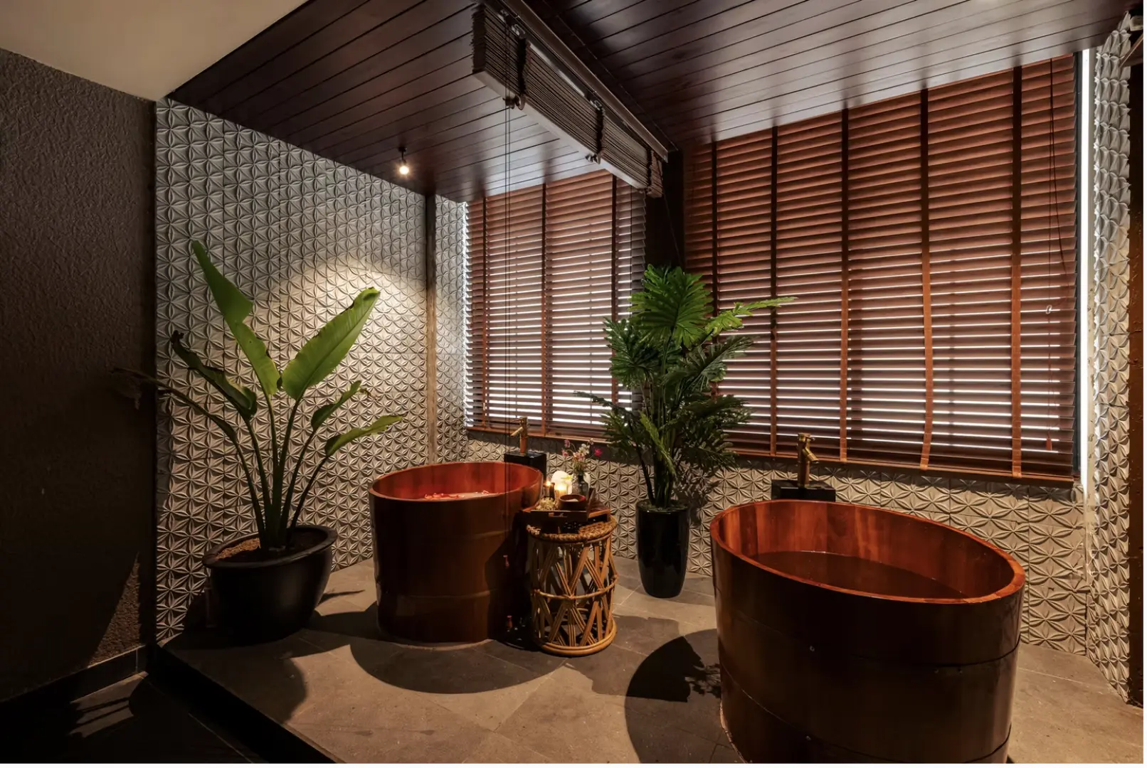 Luxurious bath therapy room at La Flora Spa in Hanoi, with two exquisite wooden bathtubs complementing tropical plants, creating a unique serene ambiance for private and relaxing spa moments.