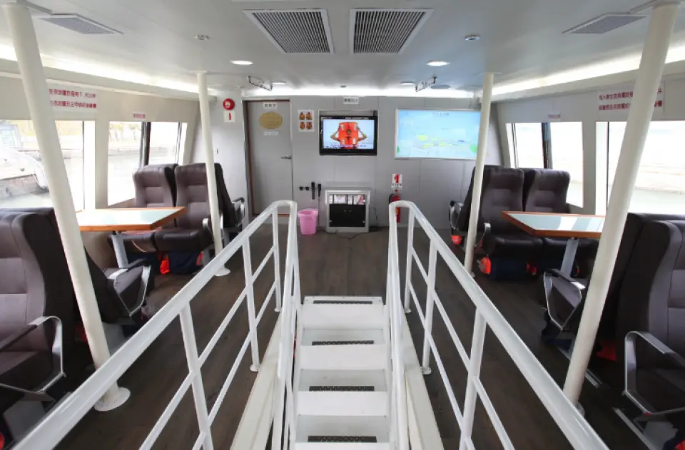 The spacious and comfortable interior of the Kaohsiung cultural yacht features luxurious seating, tables, and stairs, offering passengers the best sightseeing experience at sea.