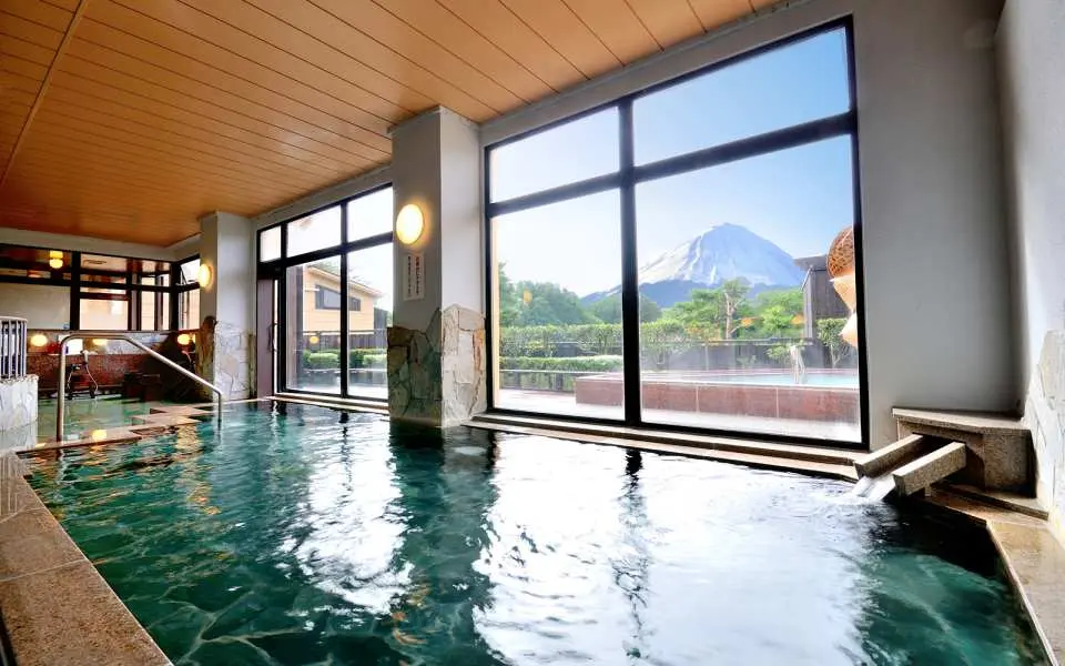 Spacious indoor panoramic bath at Yurari Onsen in Yamanashi, featuring large windows with a stunning view of Mount Fuji, perfect for a relaxing soak.