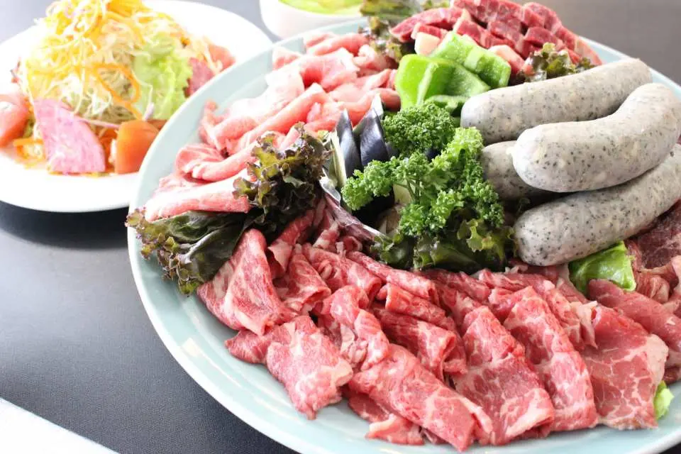 那覇ディナークルーズで提供される豪華BBQプラッター。上質な肉やソーセージ、新鮮な野菜が豊富に盛り付けられている。