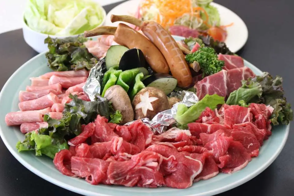 那覇クルーズディナーで楽しめるBBQコース。新鮮な各種肉、ソーセージ、野菜が豪華に盛り付けられている。