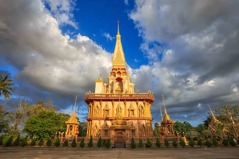 Exquisite golden Wat Chalong temple in Phuket, showcasing traditional Thai architecture with a towering spire, a revered cultural landmark and picturesque Instagram spot for visitors.