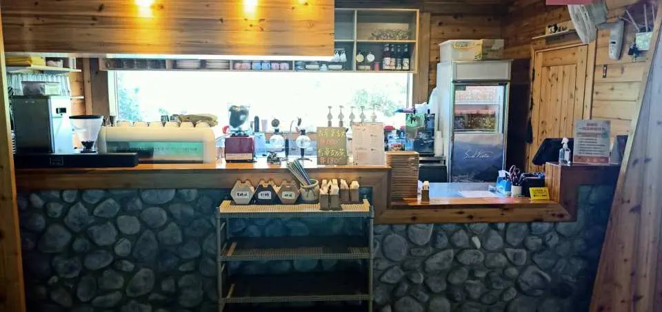 苗栗南庄蘇維拉莊園室內咖啡廳吧台，木質與石砌設計，提供各式飲品及輕食，供遊客休憩。