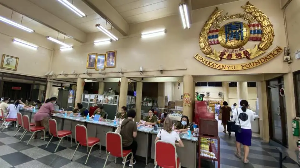 The service hall of Bangkok's Ruamkatanyu Foundation, where many devotees arrange coffin donations and other merit-making deeds, with staff actively processing various proxy services.