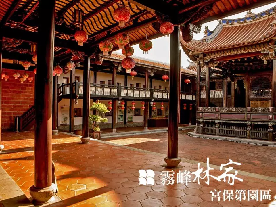 台中霧峰林家宮保第園區陽光下的寬敞庭院，多棟傳統建築與蜿蜒走廊懸掛紅燈籠，展現國定古蹟豐富的清代建築群樣貌。