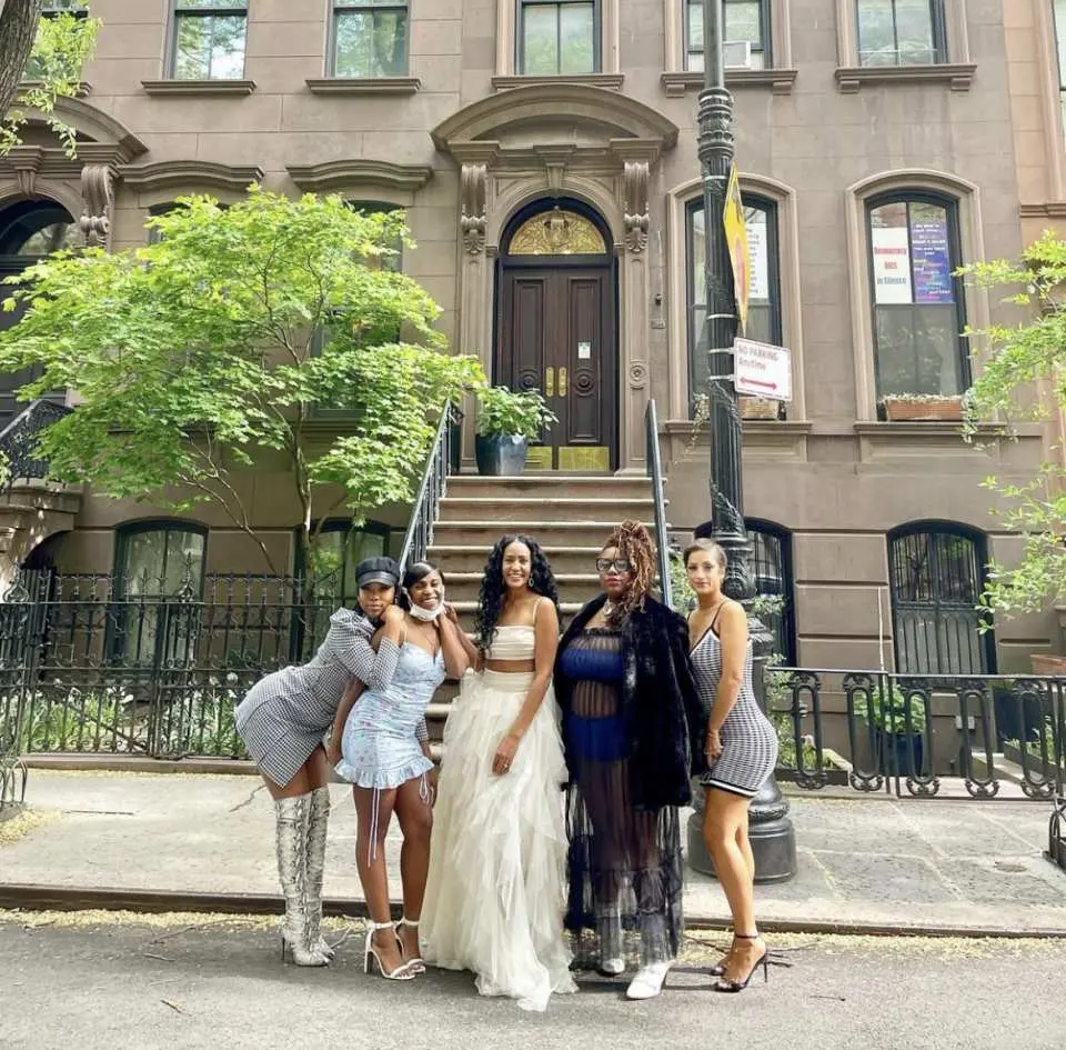 뉴욕 클래식 브라운스톤 아파트 앞 거리에서 스타일리시하게 포즈를 취하는 다섯 명의 친구들. '섹스 앤 더 시티' 테마 버스 투어의 기억에 남는 순간을 포착.