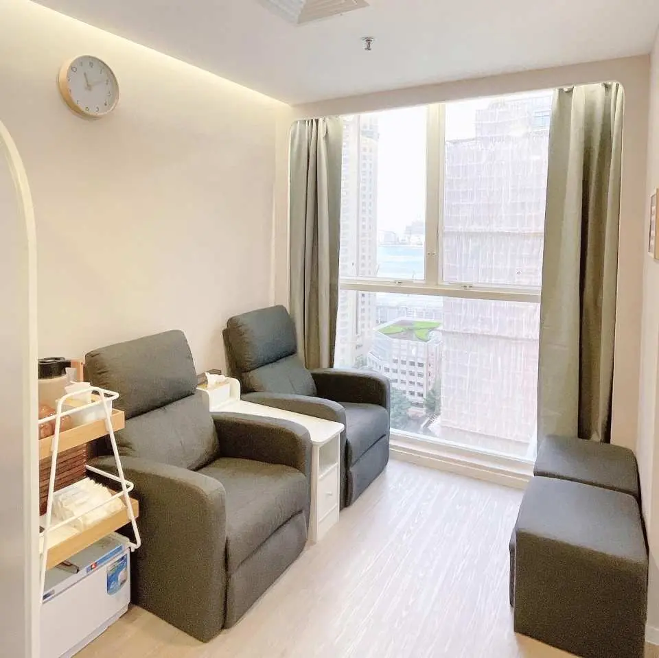 LS Spa & Massage 獨立足部按摩包廂，兩張舒適灰色躺椅，面對窗外城市美景，讓顧客在寧靜中享受專業技師的調和身心服務。