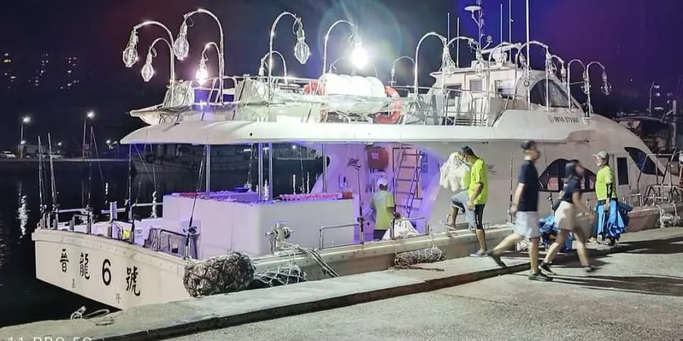 基隆碧砂漁港碼頭邊，晉龍號豪華遊艇準備啟航，遊客陸續登船享受舒適安全的夜釣體驗。
