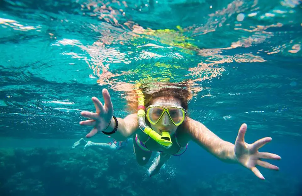 在菲律賓巴拉望本田灣的潘巴托珊瑚礁海洋保護區，一名遊客戴著浮潛面罩和呼吸管，在清澈的海水中探索色彩斑斕的珊瑚礁。