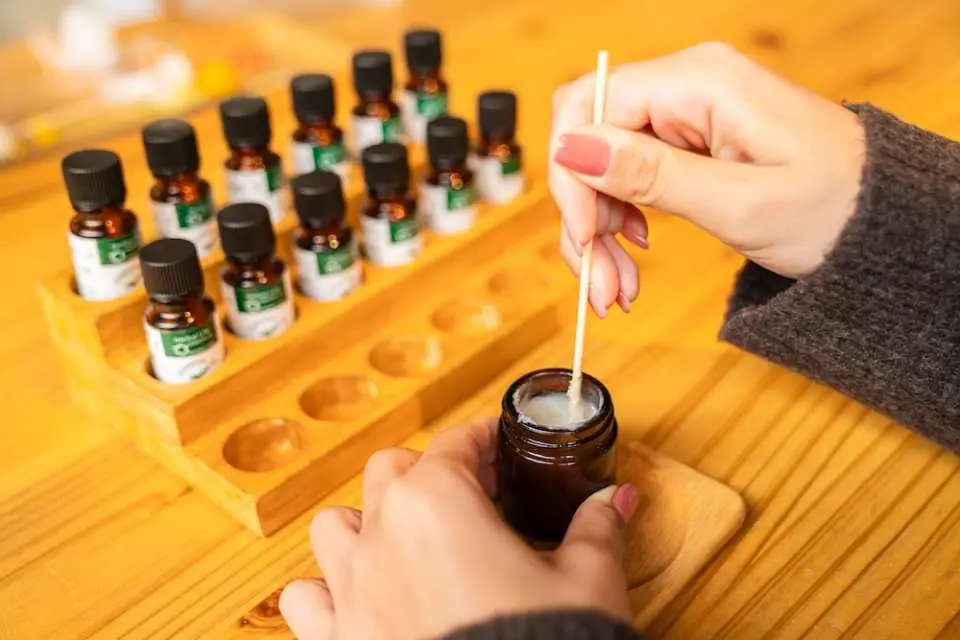 熱海ACAO FORESTの手作りワークショップのクローズアップ。訪問者が小さな瓶の中で攪拌棒を使い天然素材を集中して混ぜ合わせ、自分だけの香りやスキンケア製品を手作りする楽しみを体験しています。