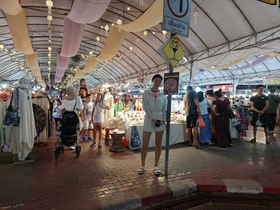 清邁室內夜市的熱鬧場景，遊客在各式攤位間穿梭購物，享受嘟嘟車夜遊帶來的道地市場與夜生活體驗。