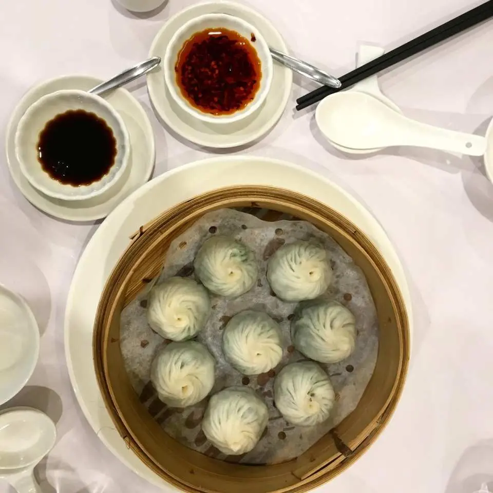 メルボルンのフードツアーで、醤油とチリソースを添えた繊細な中華風小籠包を味わい、多様なアジア料理を体験。